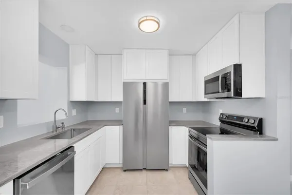 a view of kitchen with refrigerator and window