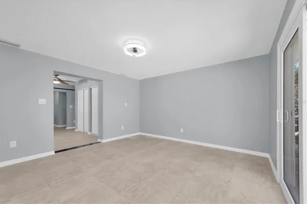 an empty room with fan and entrance