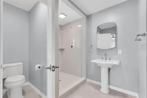 a bathroom with a sink a toilet and a mirror