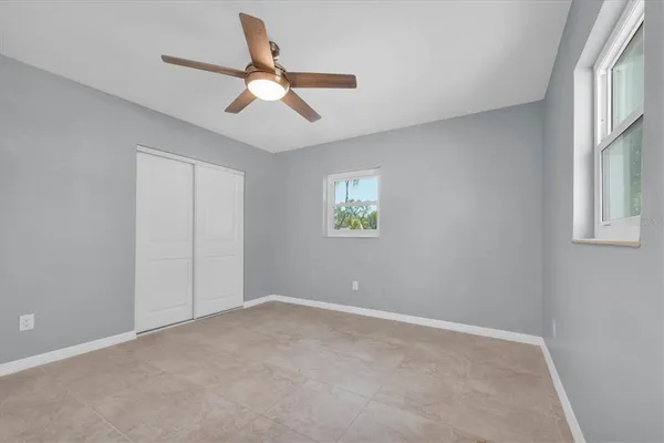 a view of a livingroom with a ceiling fan & windows