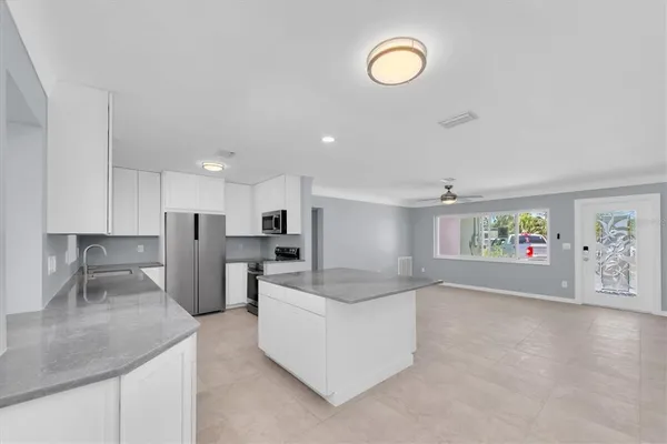 a view of a kitchen with wooden floor and a ceiling fan