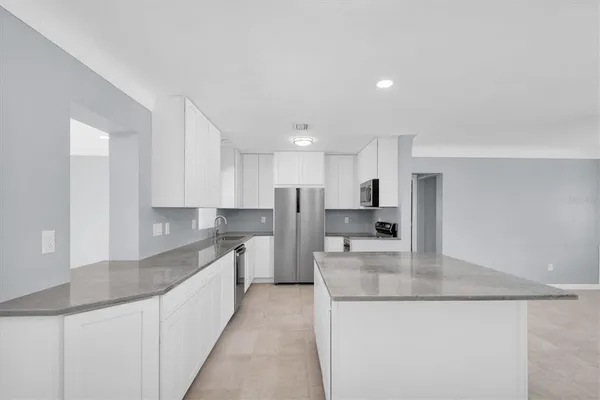 a kitchen with stainless steel appliances a stove a sink a microwave and cabinets