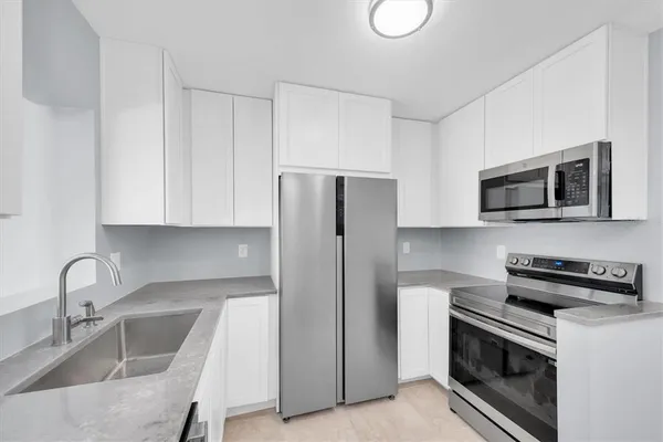 a kitchen with stainless steel appliances granite countertop a sink stove and refrigerator