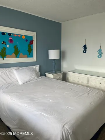 a bedroom with a bed and a painting on the wall
