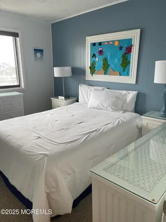 a bedroom with a bed and a painting on the wall