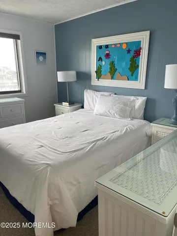 a bedroom with a bed and a painting on the wall