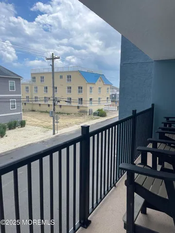 a view of a balcony with wooden chairs