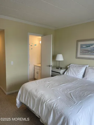 a bedroom with a bed and a lamp on dresser