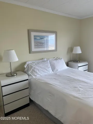 a bedroom with a bed and a lamp on dresser