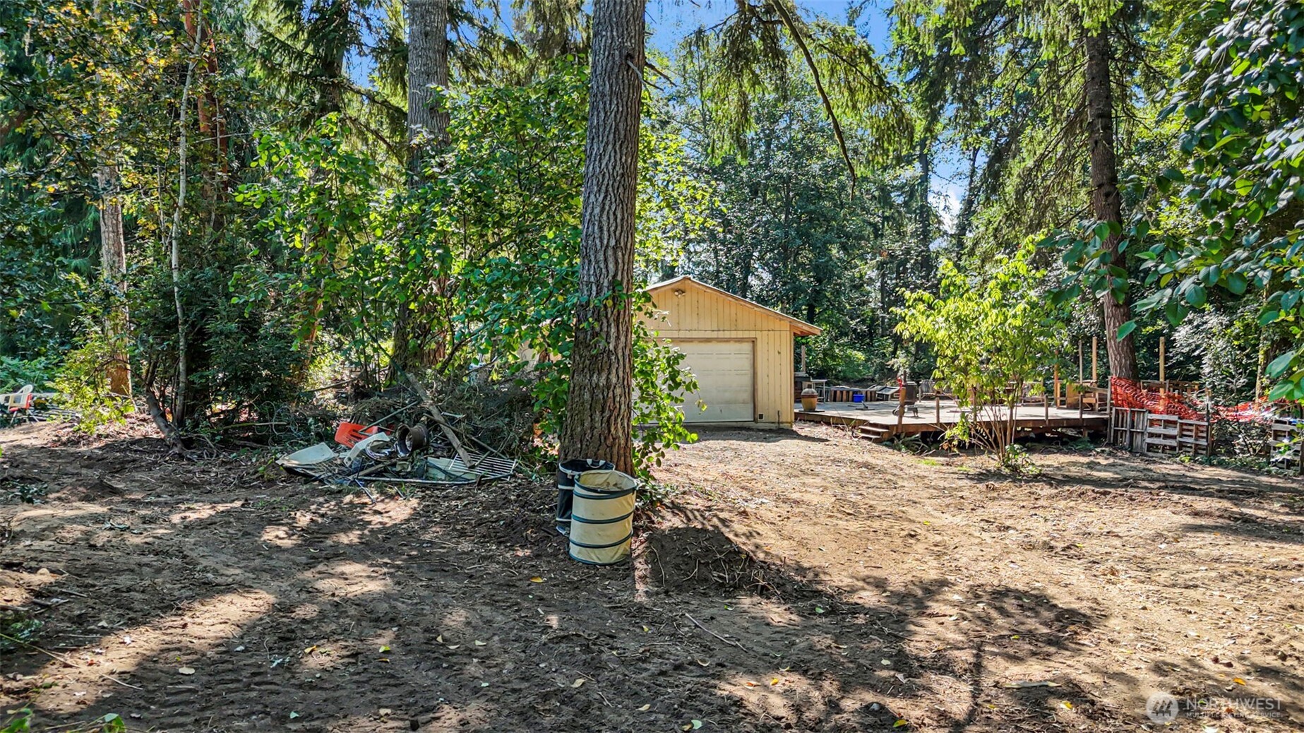 18220 70th St Court Southwest Longbranch, WA 98351 - Photo 12 of 21 a view of a backyard with large trees and wooden fence