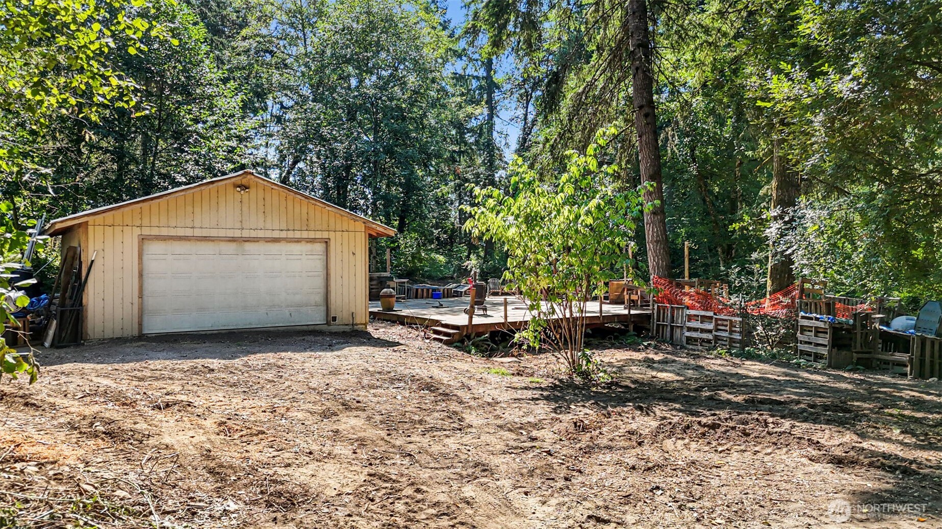 18220 70th St Court Southwest Longbranch, WA 98351 - Photo 13 of 21 a view of a small house with a large tree and a wooden fence