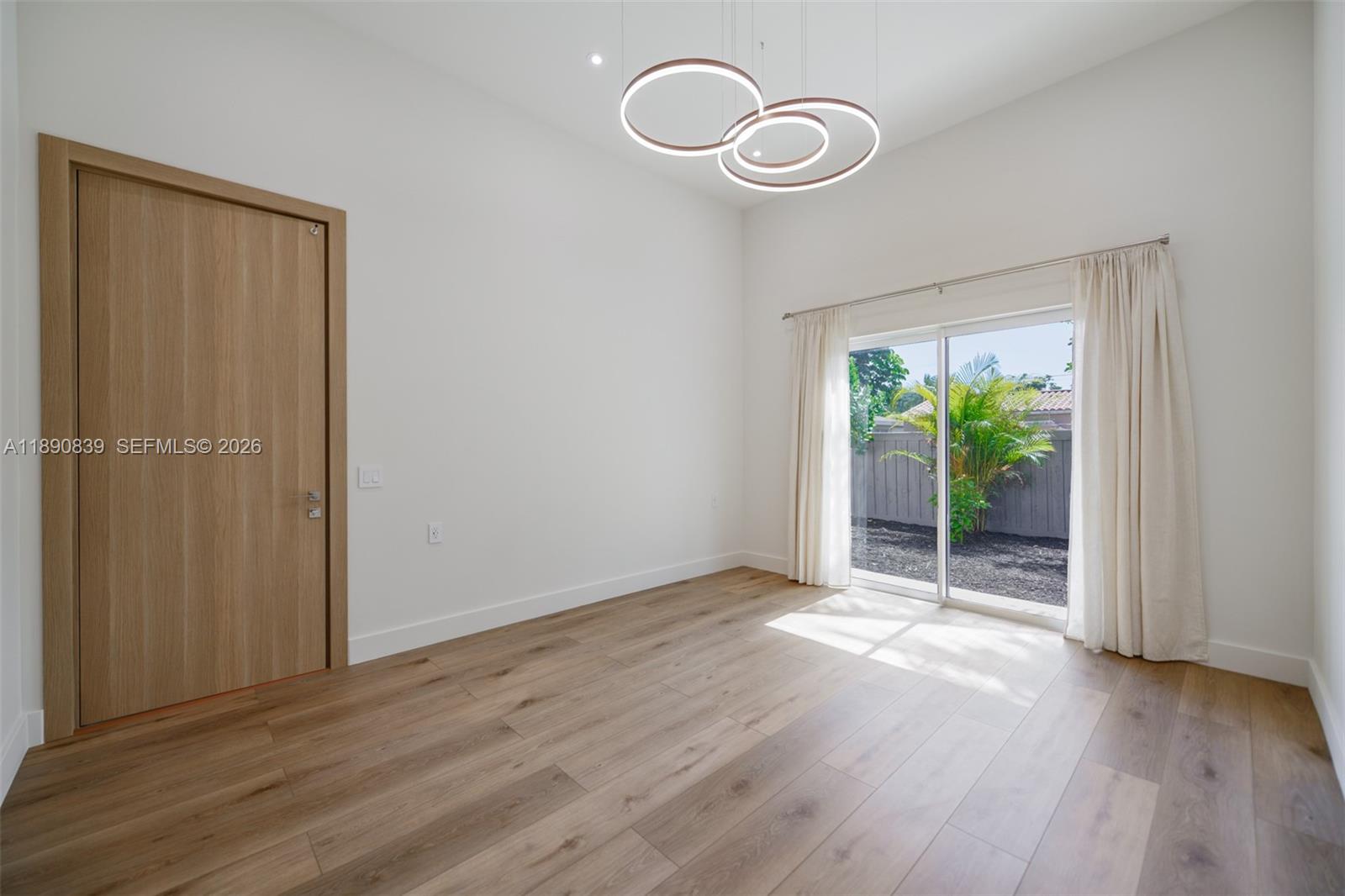 635 Southwest 9th Street Hallandale Beach, FL 33009 - Photo 12 of 38 a view of an empty room with wooden floor and window