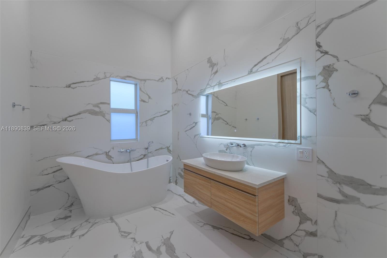 635 Southwest 9th Street Hallandale Beach, FL 33009 - Photo 15 of 38 a spacious bathroom with a double vanity sink mirror and bathtub