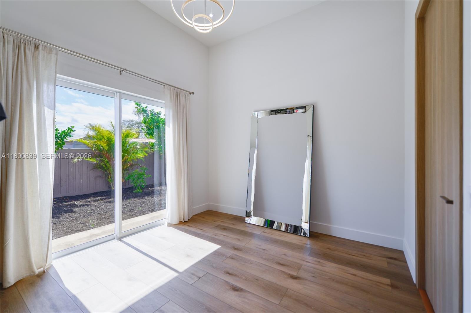 635 Southwest 9th Street Hallandale Beach, FL 33009 - Photo 20 of 38 an empty room with wooden floor and windows