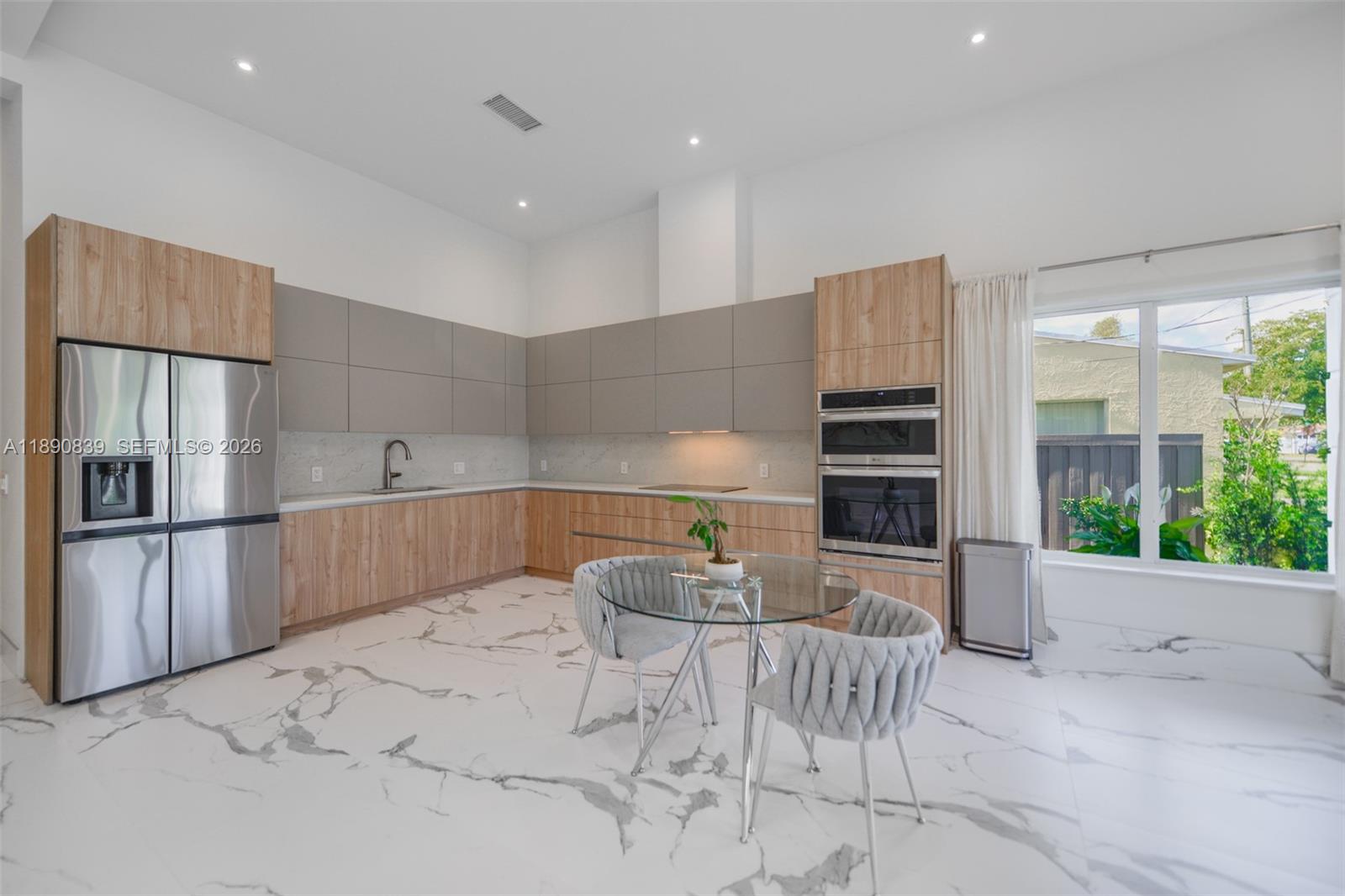 635 Southwest 9th Street Hallandale Beach, FL 33009 - Photo 7 of 38 a kitchen with stainless steel appliances kitchen island granite countertop a refrigerator and a stove