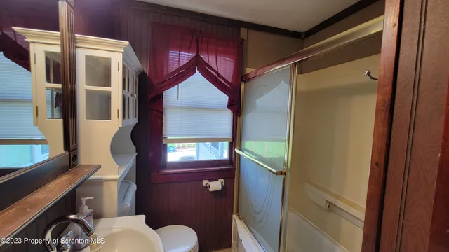 a bathroom with a toilet sink and mirror