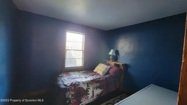 a bed sitting in a bedroom next to a window