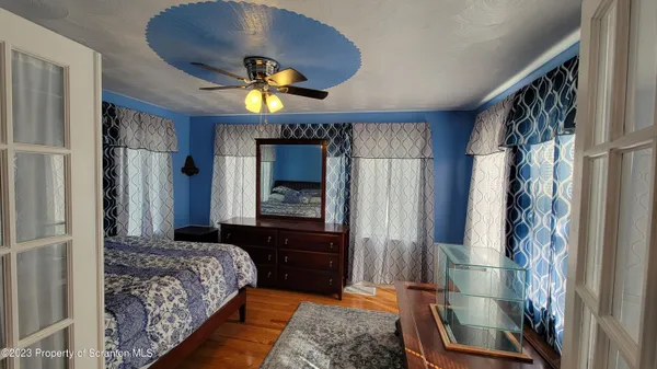 a bedroom with a bed and a mirror on the dresser