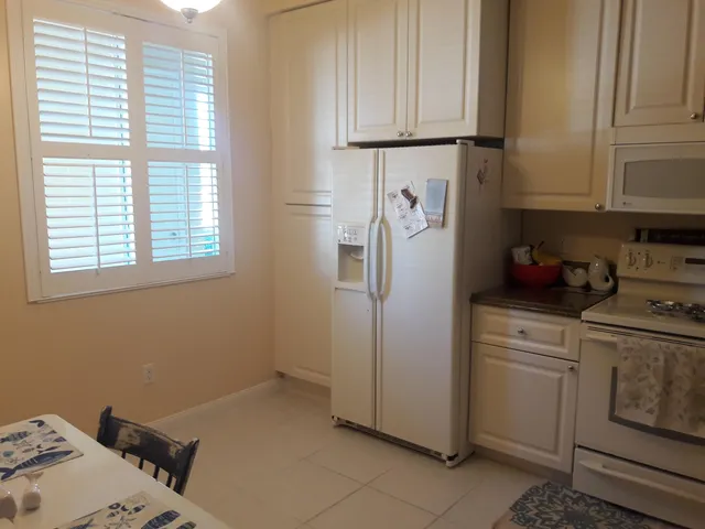 a kitchen with white cabinets and white appliances