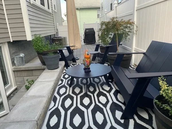 a view of a patio with couches table and chairs and potted plants