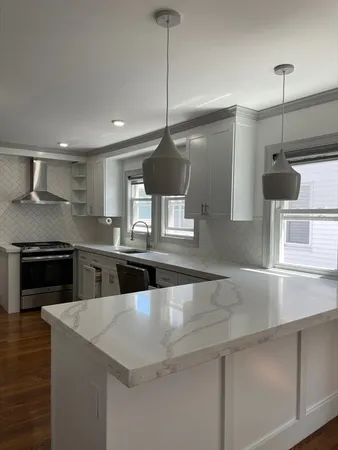 a kitchen with kitchen island a counter space a sink and stainless steel appliances