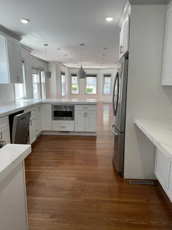 a large kitchen with a stove a refrigerator and a sink