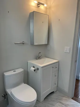 a bathroom with a toilet sink and mirror