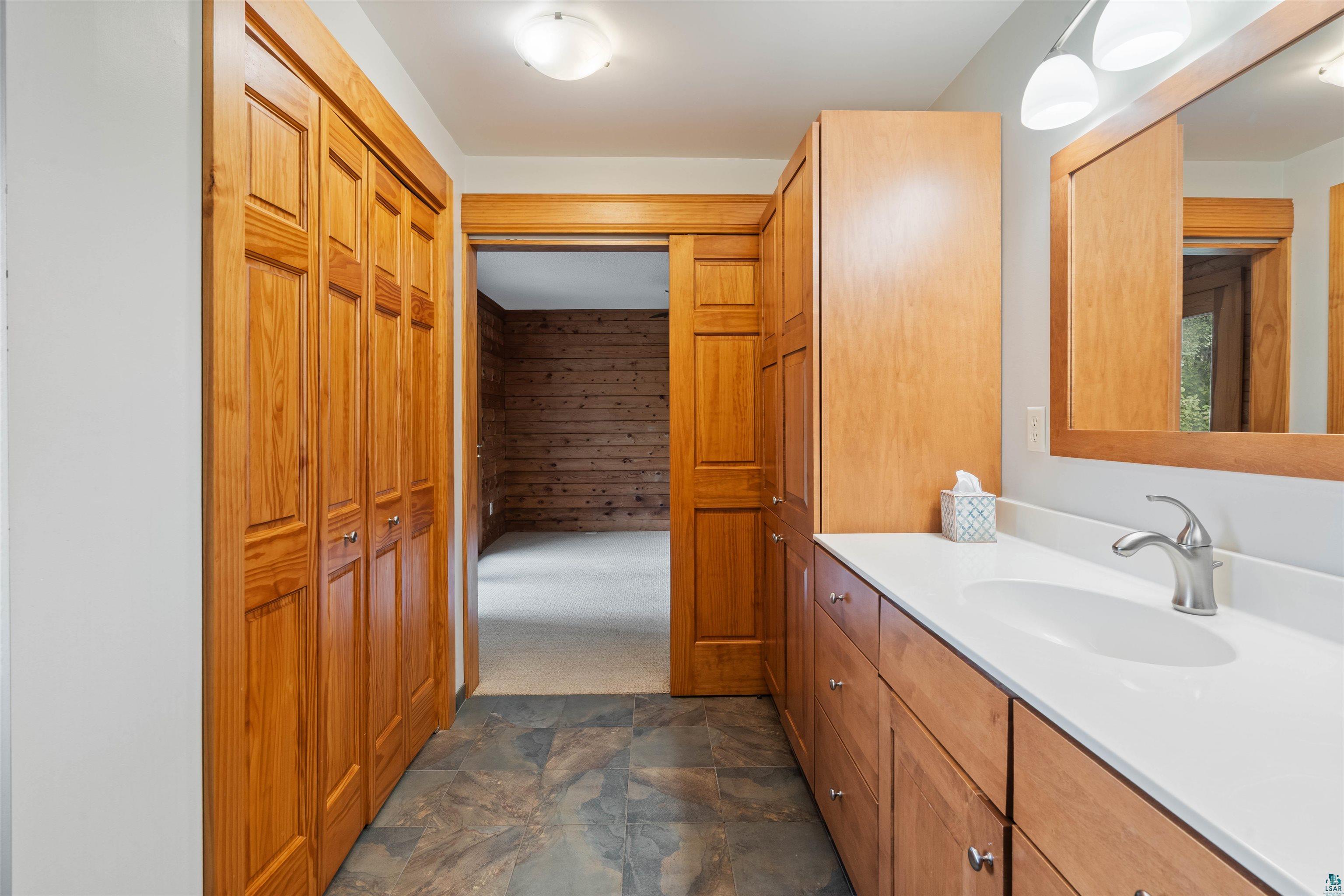 5373 Lester River Road Duluth, MN 55804 - Photo 17 of 39 Extended vanity with integrated sink, wood-finish cabinetry, and built-in storage