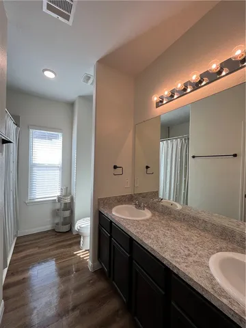 a kitchen with stainless steel appliances kitchen island granite countertop a refrigerator a oven a sink and a black cabinets