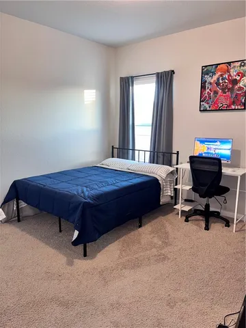 a spacious bedroom with a bed and a flat screen tv
