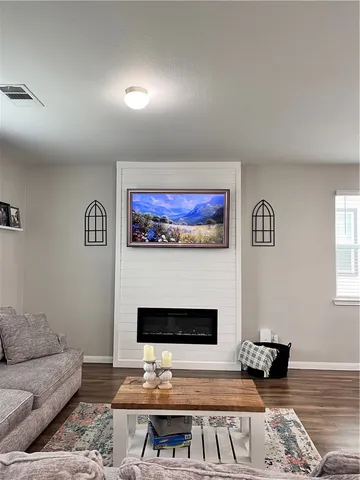 a living room with furniture a fireplace and a open kitchen view