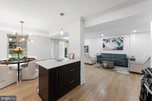 a room with a desk chairs and couches with wooden floor
