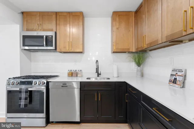 a kitchen with stainless steel appliances granite countertop a sink and a stove