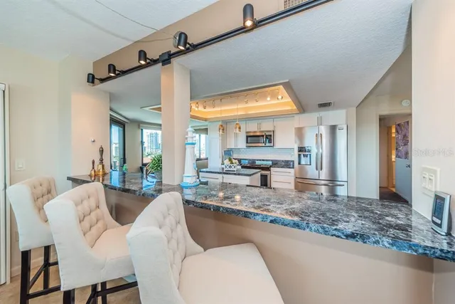 a dining hall with couches a large mirror and a dining table with wooden floor