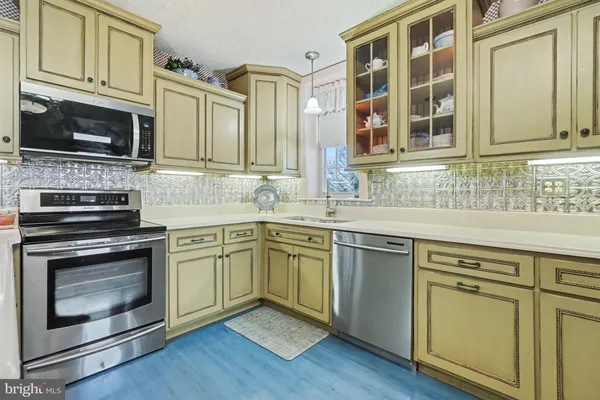 a kitchen with stainless steel appliances granite countertop a stove microwave and sink