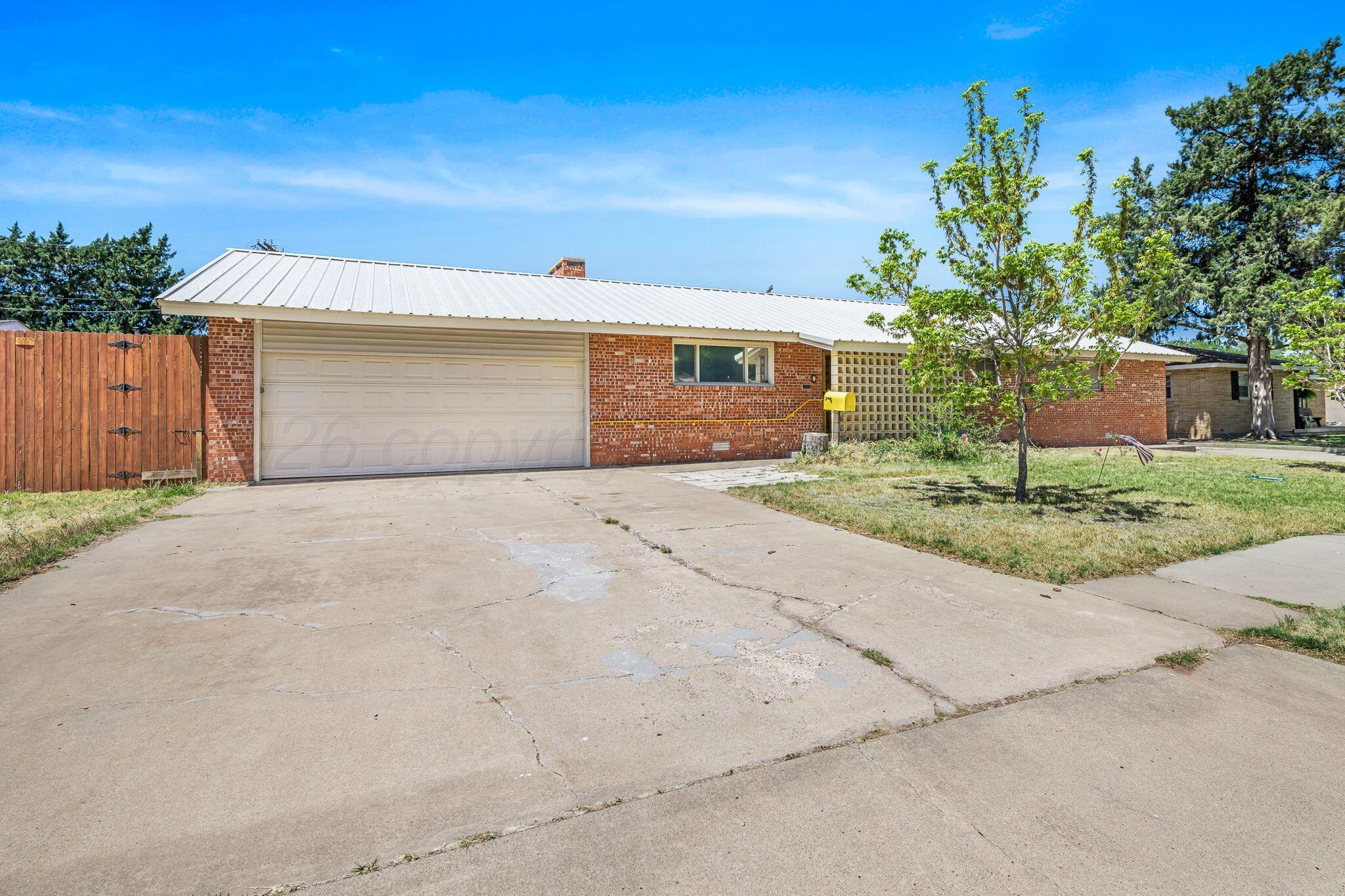 1018 South Bryan Street Amarillo, TX 79102 - Photo 1 of 41 a front view of a house with a yard and garage