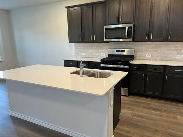 a large kitchen with stainless steel appliances granite countertop a large counter top and sink