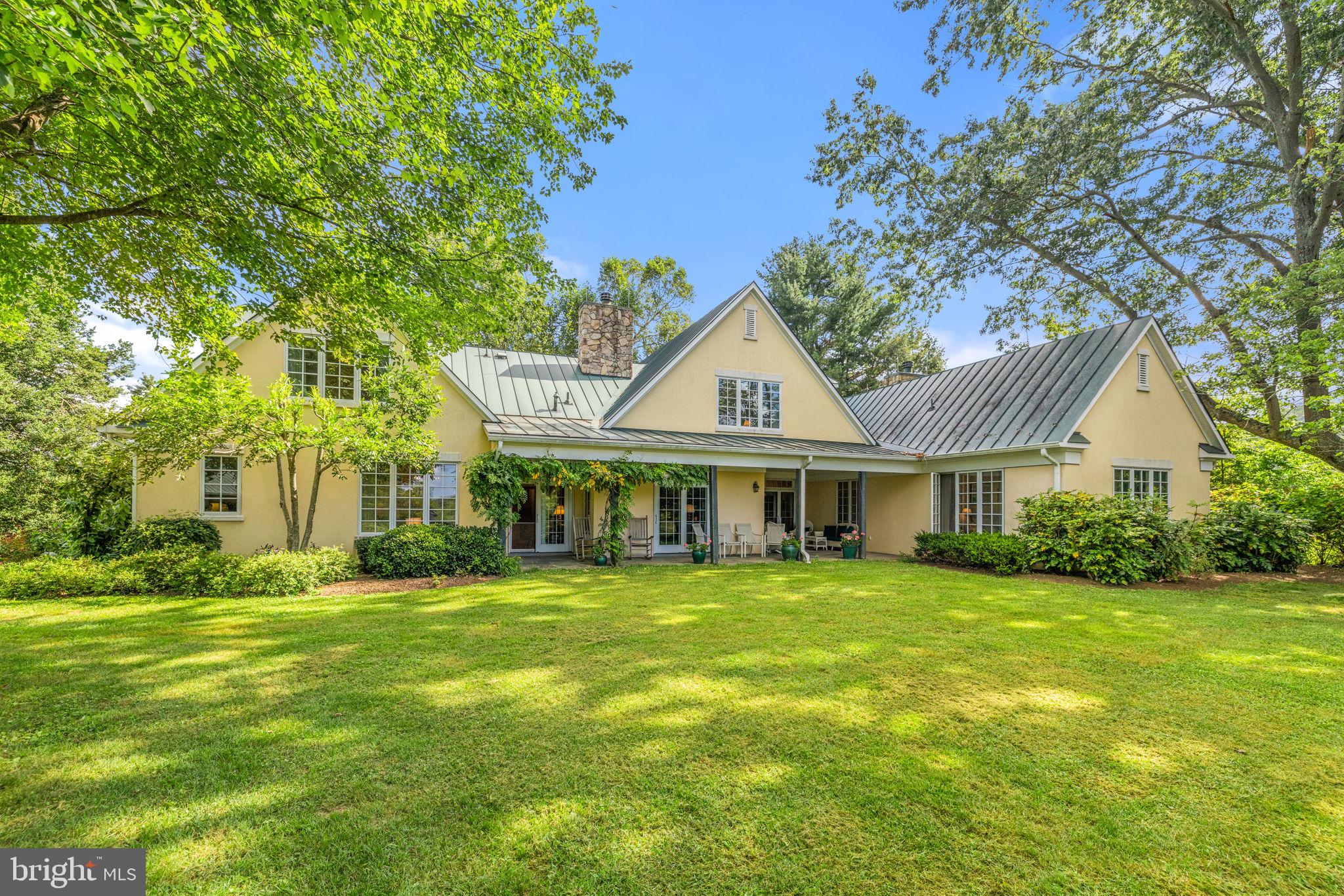 a view of a house with a big yard and palm trees