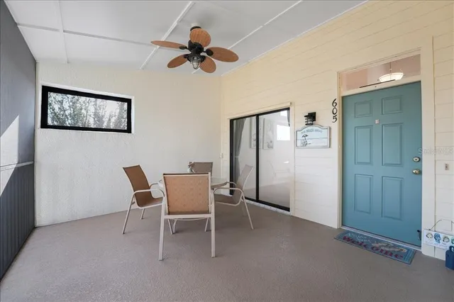 a living room with furniture a flat screen tv and a floor to ceiling window