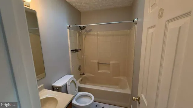 a bathroom with a shower a toilet and a tub