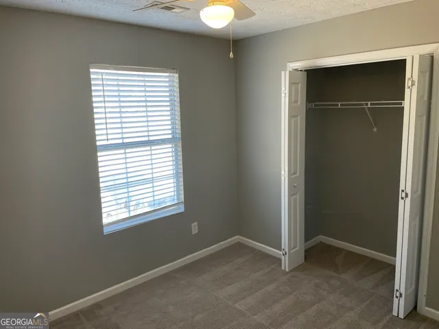an empty room with windows and closet
