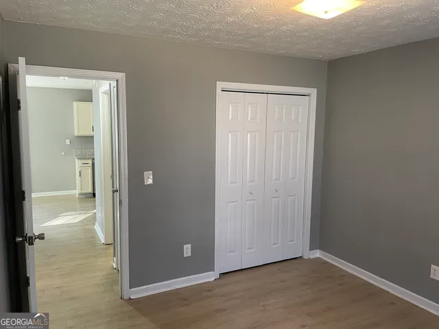 an empty room with closet and a bathroom