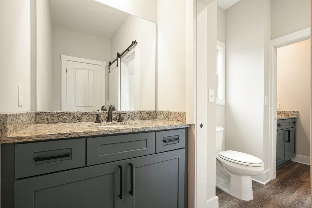 4749 Fowler Street Acworth, GA 30101 - Photo 38 of 60 a bathroom with a granite countertop toilet sink and mirror
