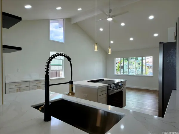 a kitchen with stainless steel appliances granite countertop a sink a stove and a refrigerator