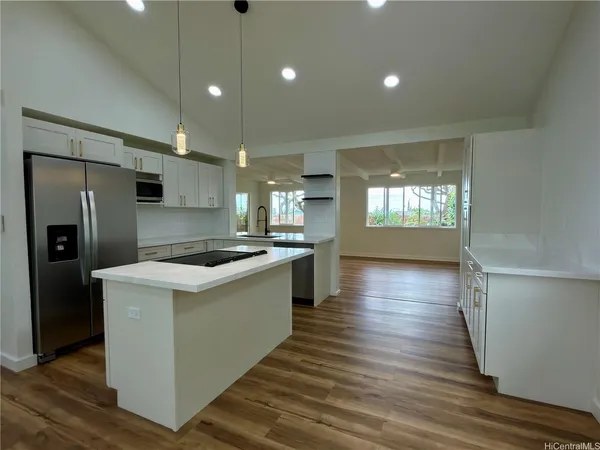 a large kitchen with stainless steel appliances granite countertop a lot of counter space and wooden floor