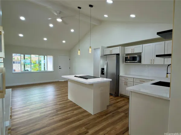a kitchen with kitchen island stainless steel appliances sink stove microwave and cabinets