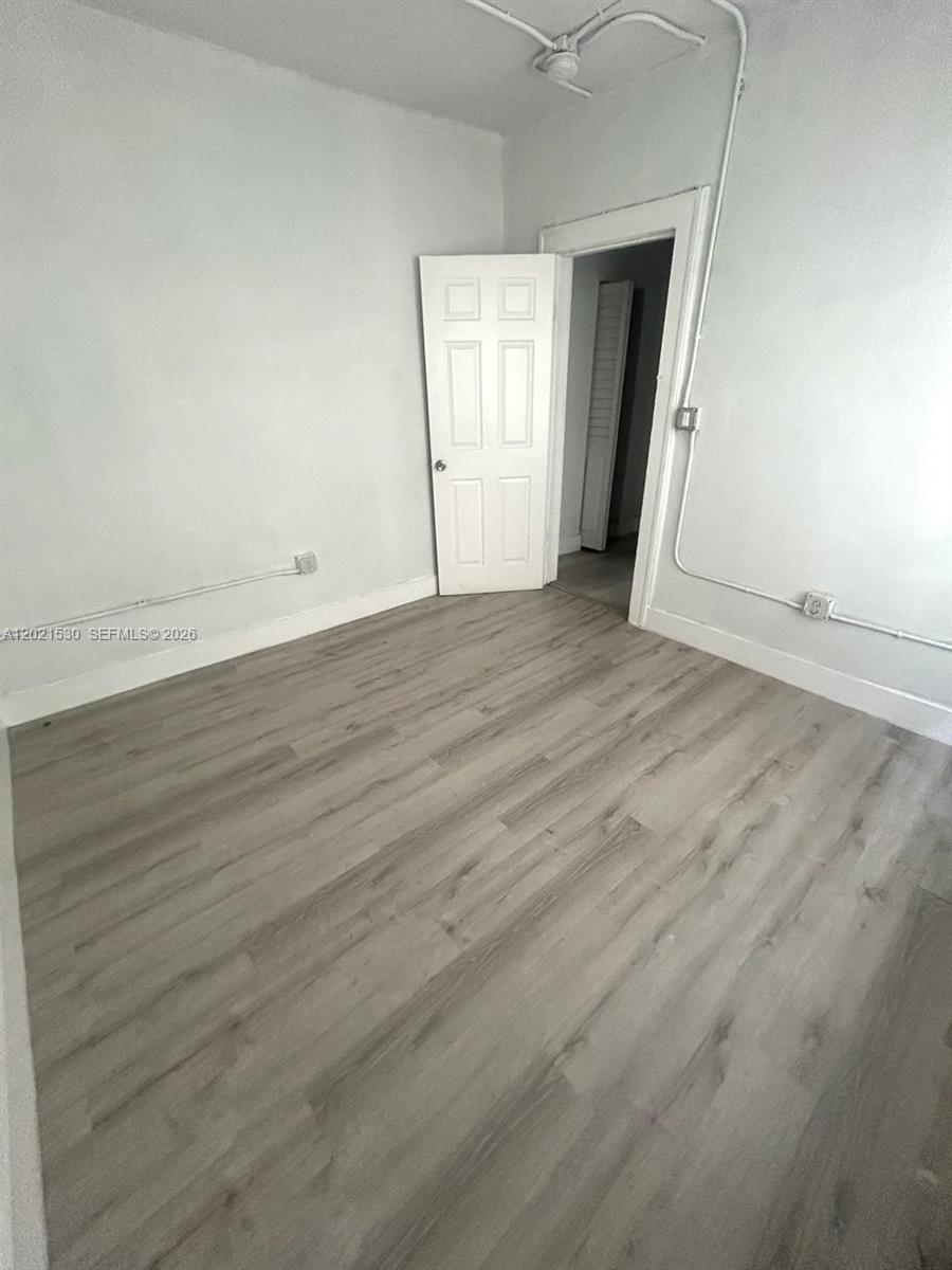 967 Southwest 5th Street, Unit 10 Miami, FL 33130 - Photo 7 of 9 an empty room with wooden floor and closet