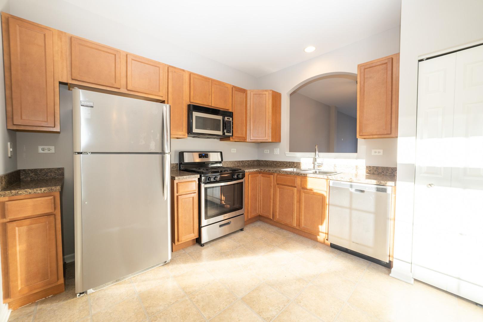 4313 Timber Ridge Court Joliet, IL 60431 - Photo 8 of 25 a kitchen with white cabinets and stainless steel appliances