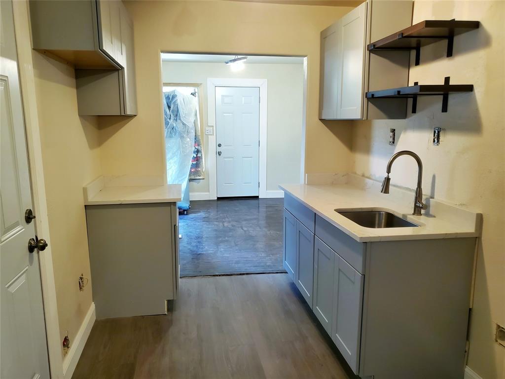 a kitchen with a sink a refrigerator and cabinets