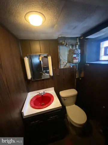 a bathroom with a toilet sink and mirror